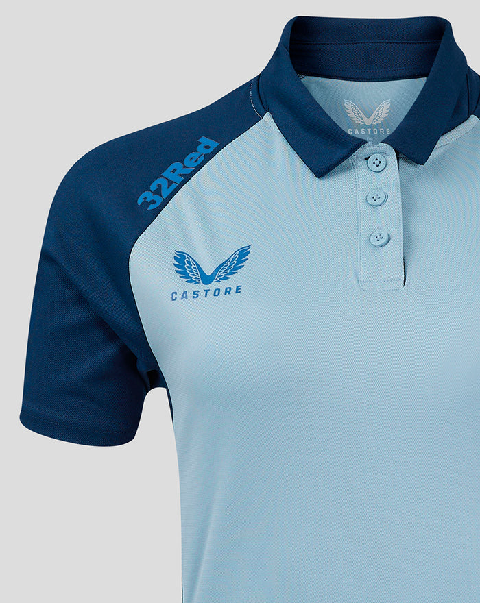 Close-up of the polo chest area featuring light blue body navy shoulder panel left chest crest and Castore branding