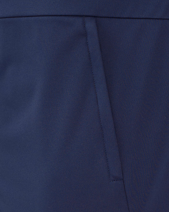 Navy travel jacket waist close up showing angled pocket seam and clean paneling