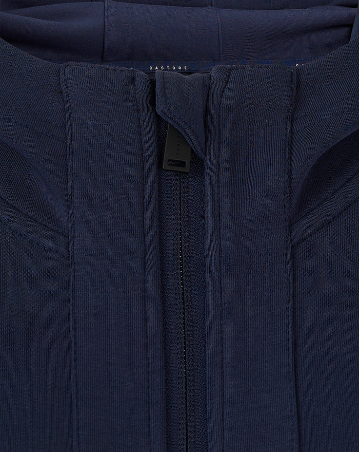 Rear close-up of navy hooded travel jacket showing hood edge and upper back