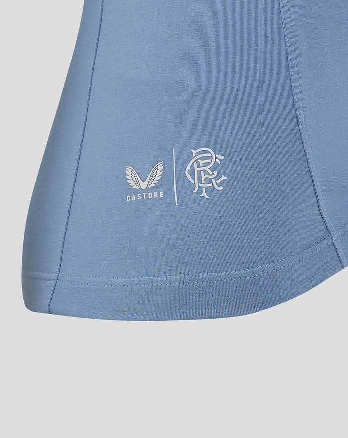 Close-up of the light blue polo showing Castore logo and club crest near the hem on the lower left side