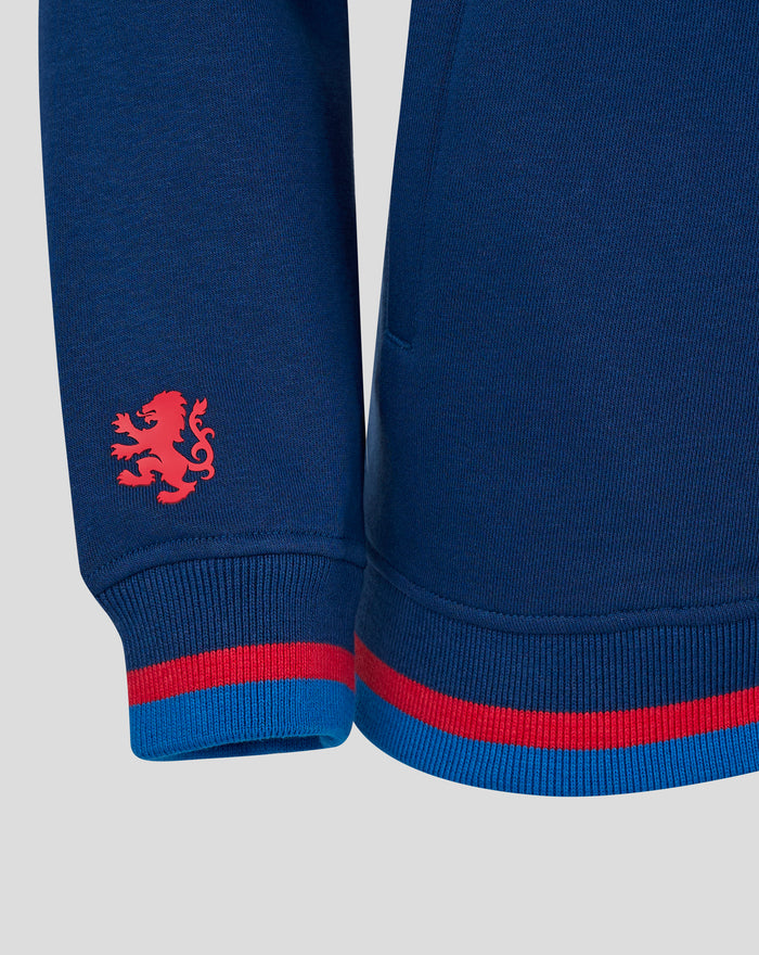 Navy hoodie close up showing red crest patch on the lower left sleeve and red and blue striped cuffs.