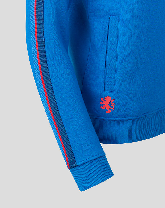 Blue hoodie sleeve close up with two tone stripe and ribbed cuff and pocket edge and red crest