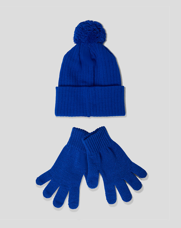 Blue junior beanie with pom and matching knit gloves arranged together.