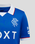 Rangers FC Junior 25/26 Home Shirt close up blue jersey with white collar and red trim, Umbro logo right chest and crest left.