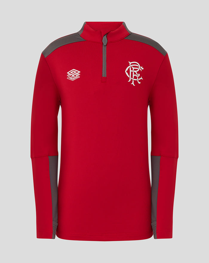 Red junior training top with grey shoulders and small brand logo on left, white crest on the right chest.
