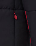 Close-up of the red zipper pull and front seam on the black padded jacket.