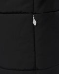 Shoulder and chest detail of black padded jacket with light grey panel and Castore branding