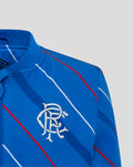 Close-up of blue jacket chest showing diagonal stripes and the white club crest