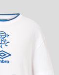 Close up on the blue crest and Umbro logo printed on the white T-shirt.