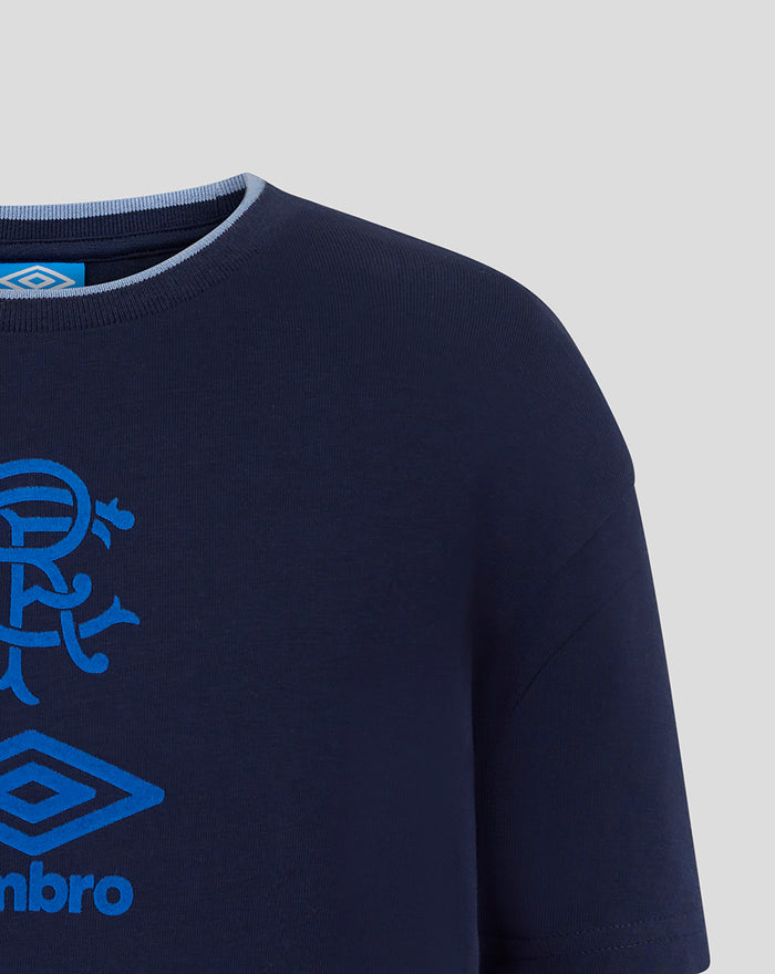 Shoulder and chest close-up of navy T shirt showing blue Umbro diamond logo and partial crest.