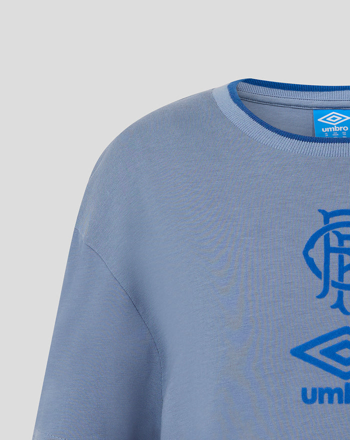 Close up of the grey jersey neckline and shoulder with blue Umbro tag at the collar and partial crest.