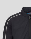 Shoulder close-up of navy Junior Travel Track Jacket with white piping along the seam and blue Umbro tag at the collar.