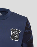 Close up of navy junior matchday tee showing club crest on chest and camouflage sleeve detail