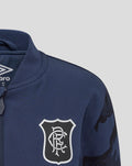 Close-up of navy jacket chest showing the club crest and Umbro branding at the collar.