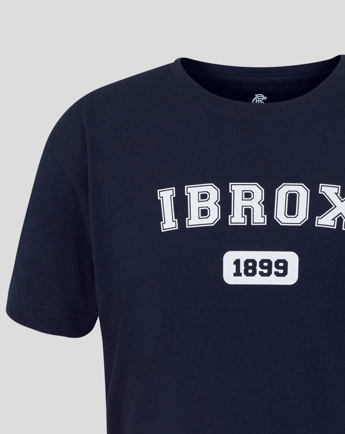 Navy junior Ibrox varsity tee close up of neckline with large white outlined IBROX across the chest and a 1899 sticker