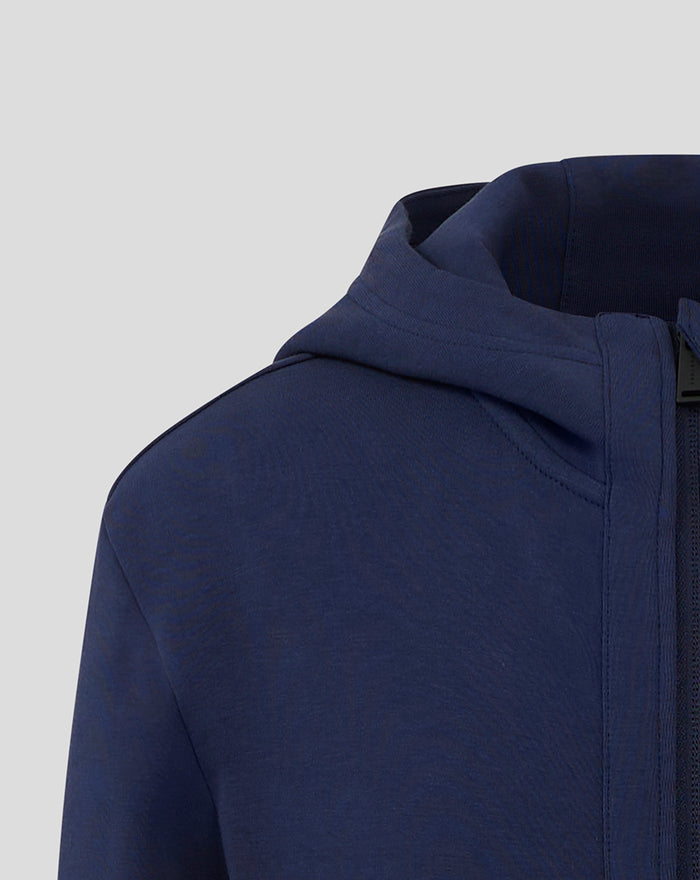 Close-up of navy hooded travel jacket neckline showing hood and zipper guard at the front