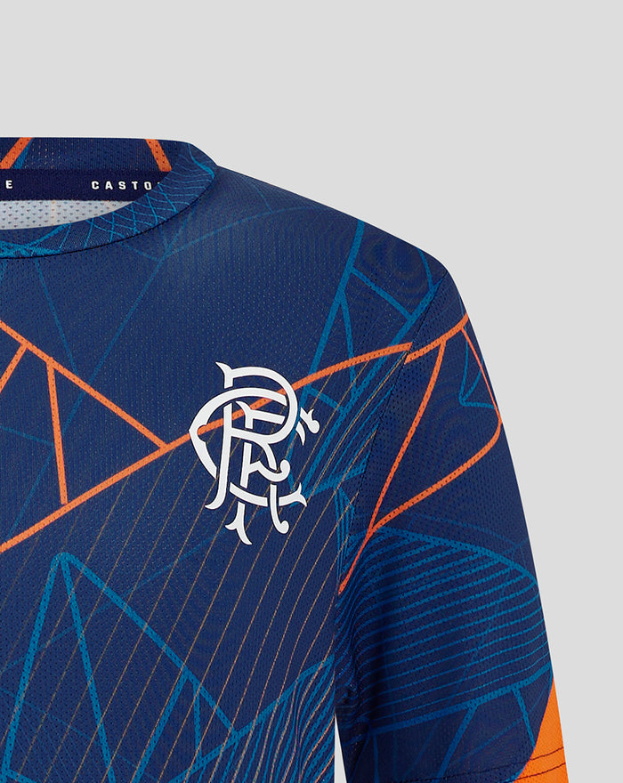 Close-up of the left chest on the blue geometric jersey showing a white winged crest and Castore branding inside the collar