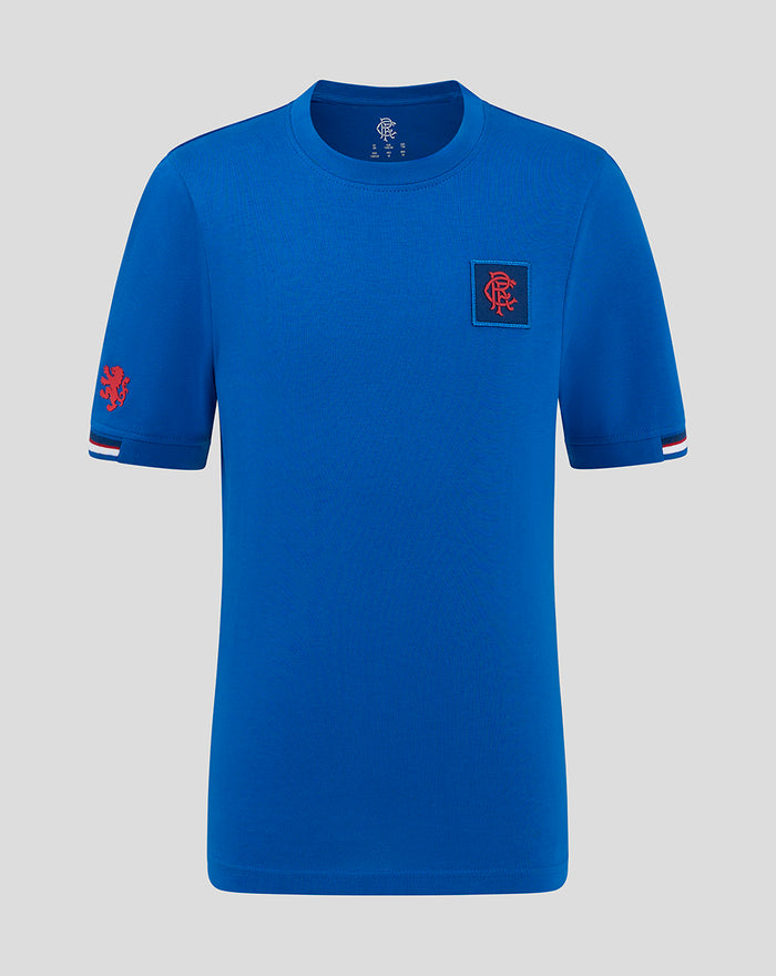 Blue junior classic cotton T shirt with a red crest patch on the left chest and striped sleeve cuffs