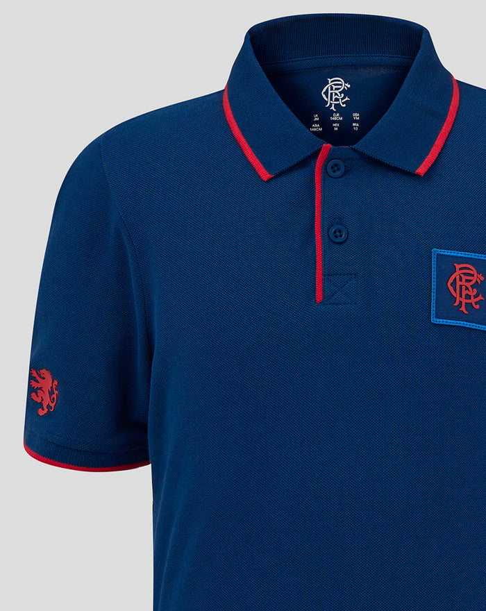Upper chest close-up of navy junior polo with a blue bordered crest patch