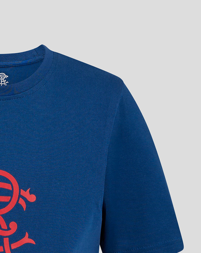 Partial view of the red crest graphic on the navy T shirt near the lower front