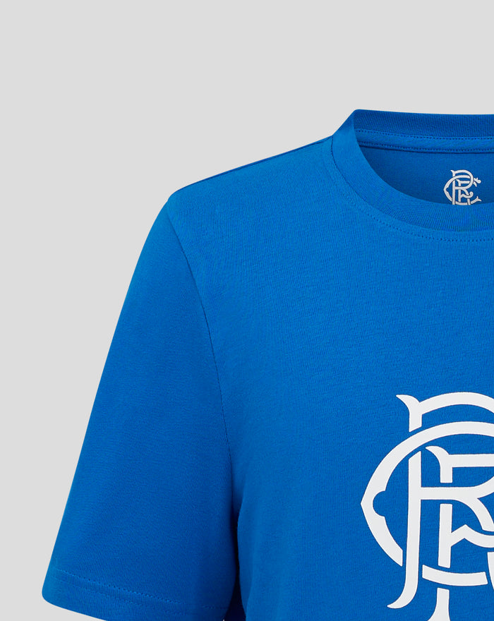 Close up of blue Junior Core Crest T shirt showing a white crest logo on the chest.
