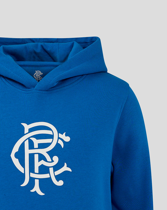 Blue hooded sweatshirt close up showing folded hood and small crest emblem at the neckline