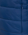 Close up of the navy puffer jacket showing the zipper and horizontal quilt stitching across the panel.