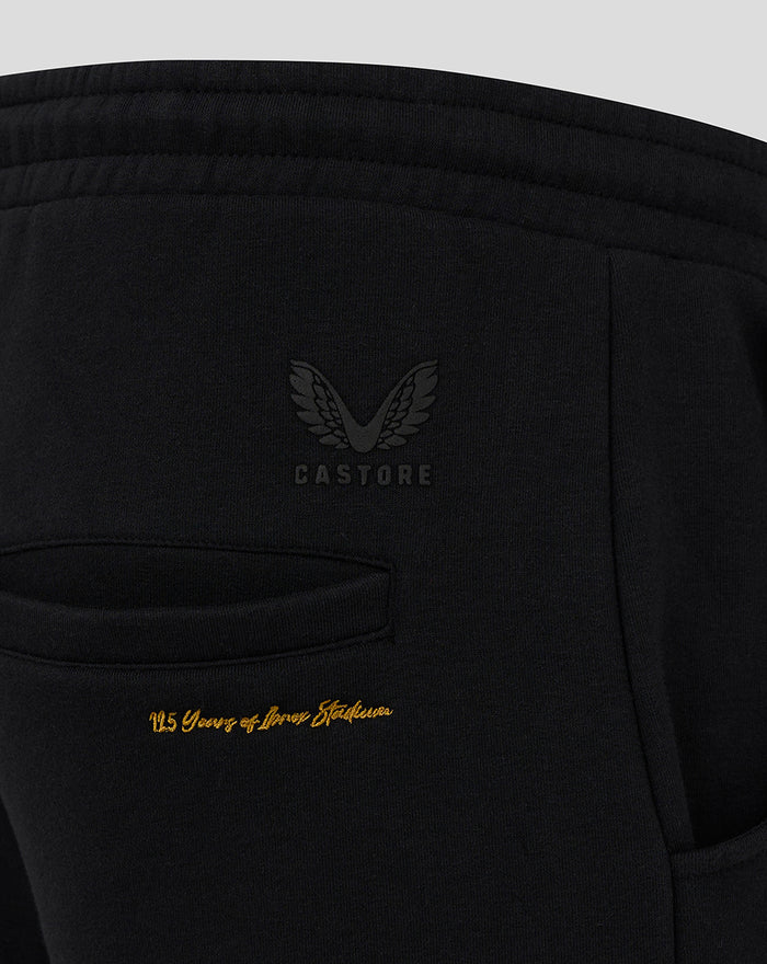Close up of back pocket on black Rangers jogger showing Castore logo and gold 125 Years of Ibrox Stadium script.
