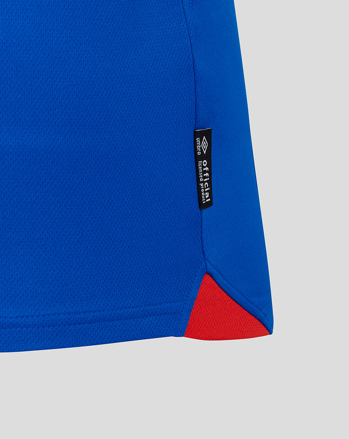 Close-up of blue Rangers FC 25/26 home shirt hem showing a red side insert and an official licensed product tag.
