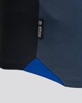 Close-up of the black side seam tag on the navy shirt showing official Umbro branding