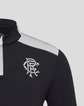 Close up of a black training quarter zip with a white club crest on the left chest