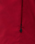 Close up of red training jacket fabric with a black zipper pull