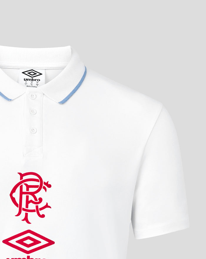 Close-up of white polo collar with blue trim showing red crest on chest and part of the Umbro logo