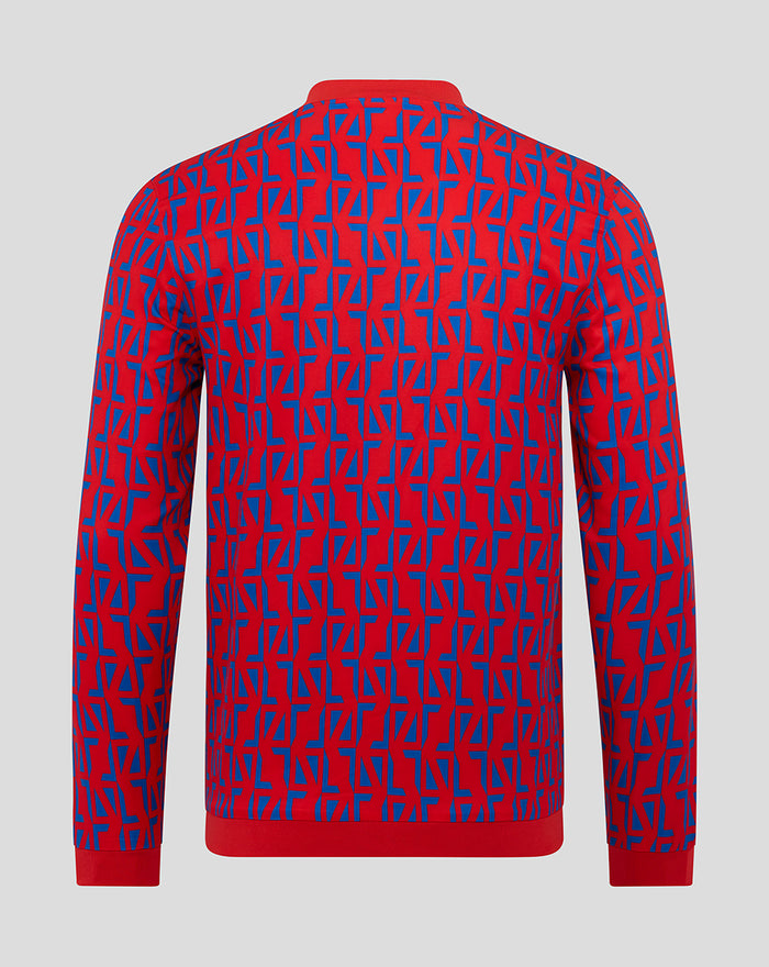 Back view of a red and blue geometric print unisex away matchday jacket with red cuffs and hem.