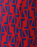 Close-up of red fabric with blue geometric print and a red zipper pull on the away jacket.