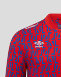Chest view of the jacket showing white Umbro logo on red and blue geometric print.