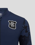 Close up of navy jacket chest displaying club crest and Umbro logo with camo sleeve panel