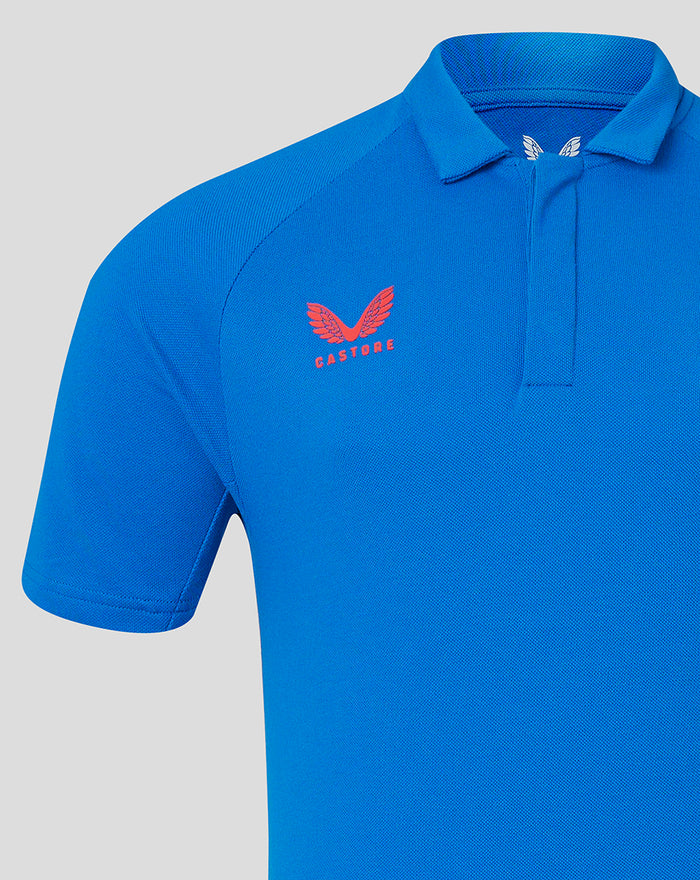 Blue polo shirt close-up highlighting the club crest on the chest with Castore branding nearby.
