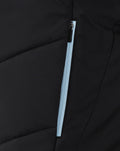 Close-up of black Rangers Pro Coaches bench jacket showing a vertical light blue zipper and panel stitching.
