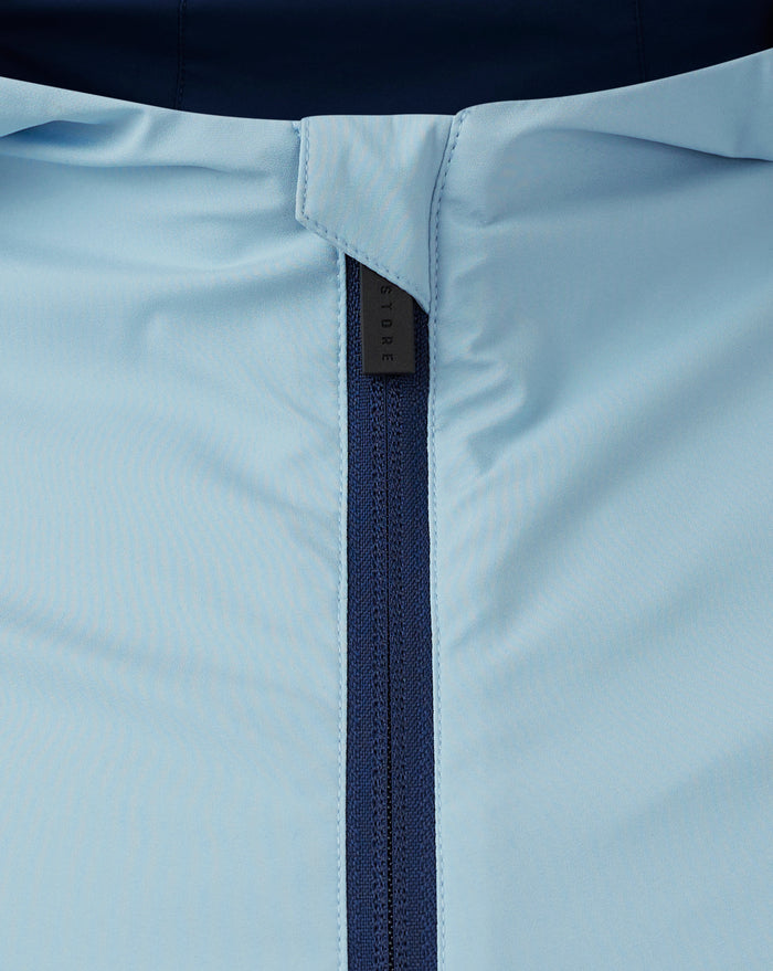 Close-up of light blue fabric with navy zipper on a Rangers training jacket