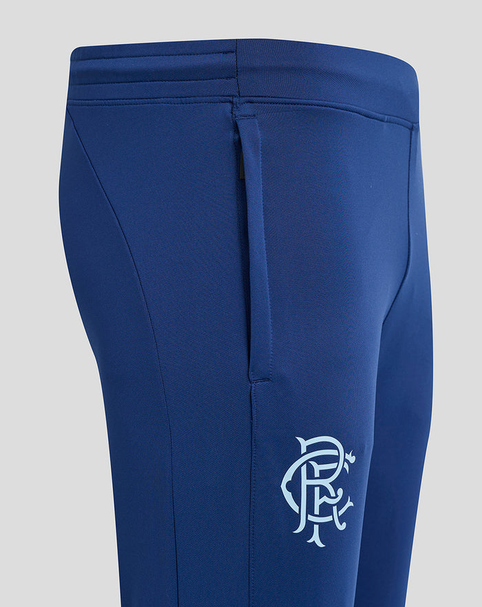 Close up of navy blue pants showing the waistband with belt loop and a white crest logo on the right thigh