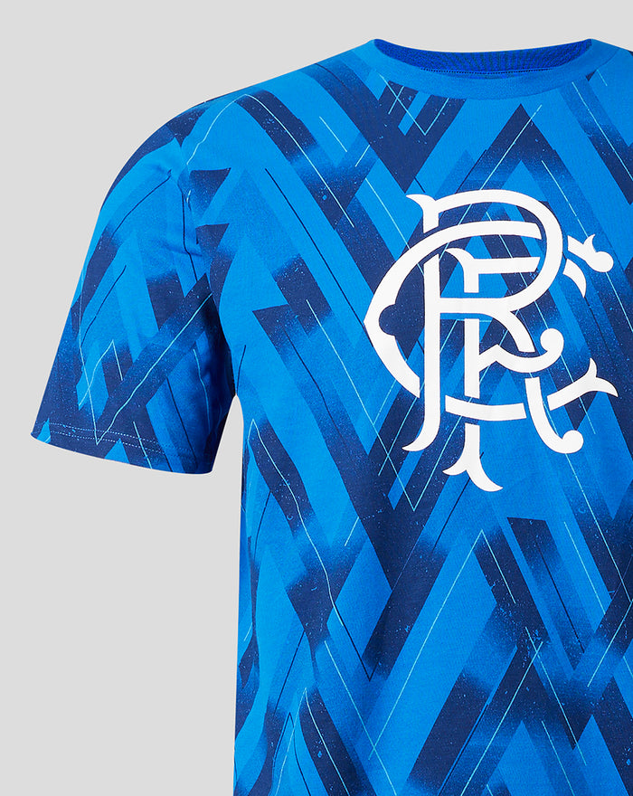 Blue geometric print short sleeve pajama top with a large white monogram crest.
