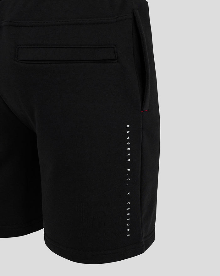 Side view of black men's 24/25 shorts with vertical Rangers FC Castore lettering along the leg and a small red stitch by the pocket