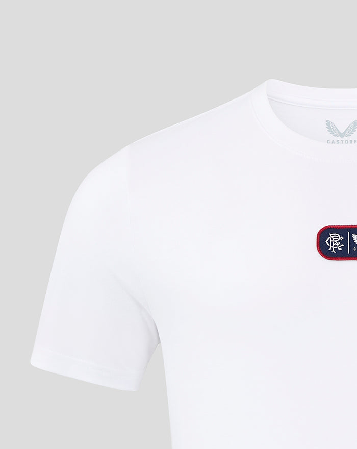 Close-up of white t shirt neckline and shoulder with inner Castore label and partial chest patch.