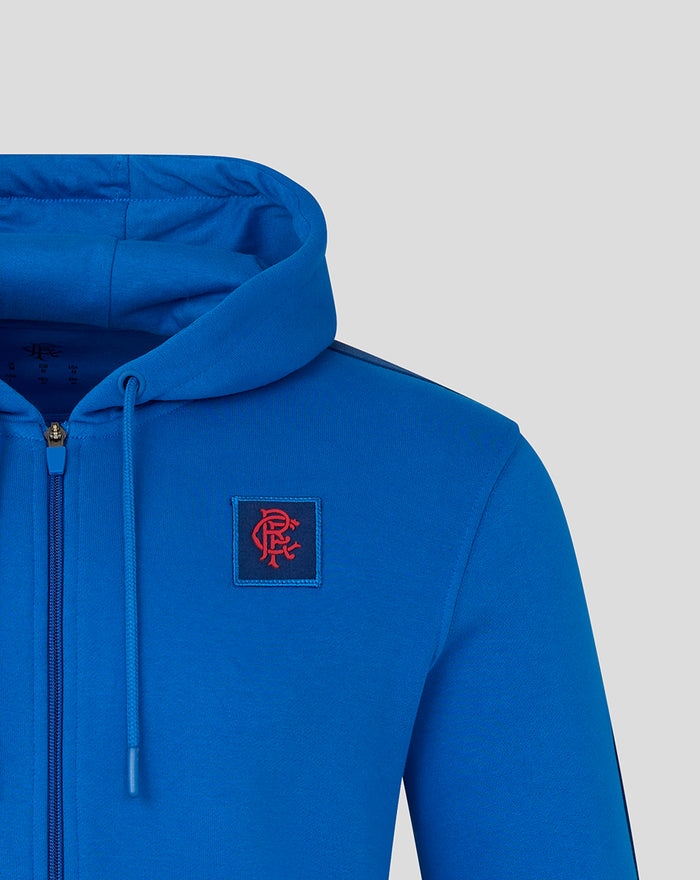 Blue hoodie with left chest logo patch and zip detail.