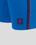 Close up of blue Junior Classic Rangers Shorts showing a red crest patch near the hem and a red side stripe.