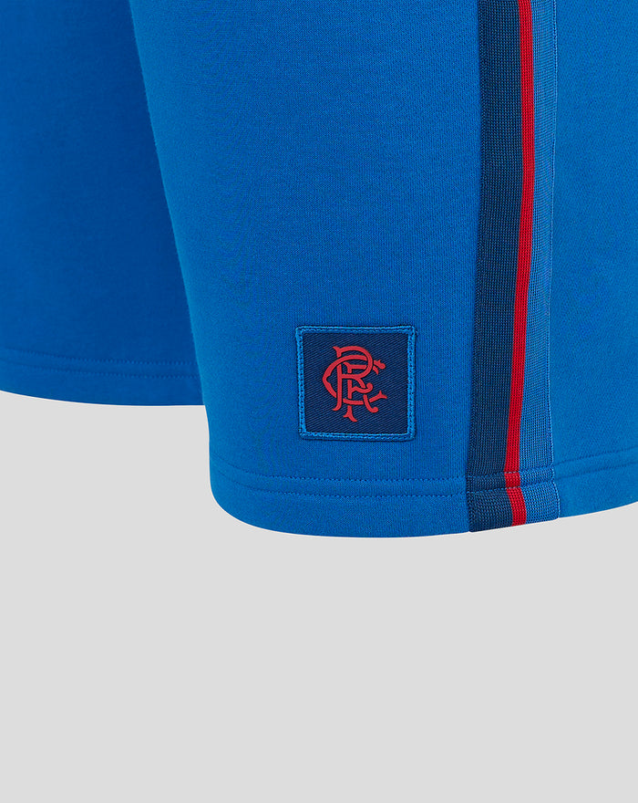 Close up of blue Junior Classic Rangers Shorts showing a red crest patch near the hem and a red side stripe.