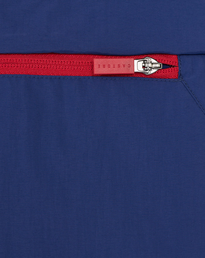 Close-up of blue nylon fabric with a red zipper pull on a men's anorak.