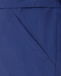 Blue men's anorak sleeve with a red bordered patch featuring white crest and Castore logos.