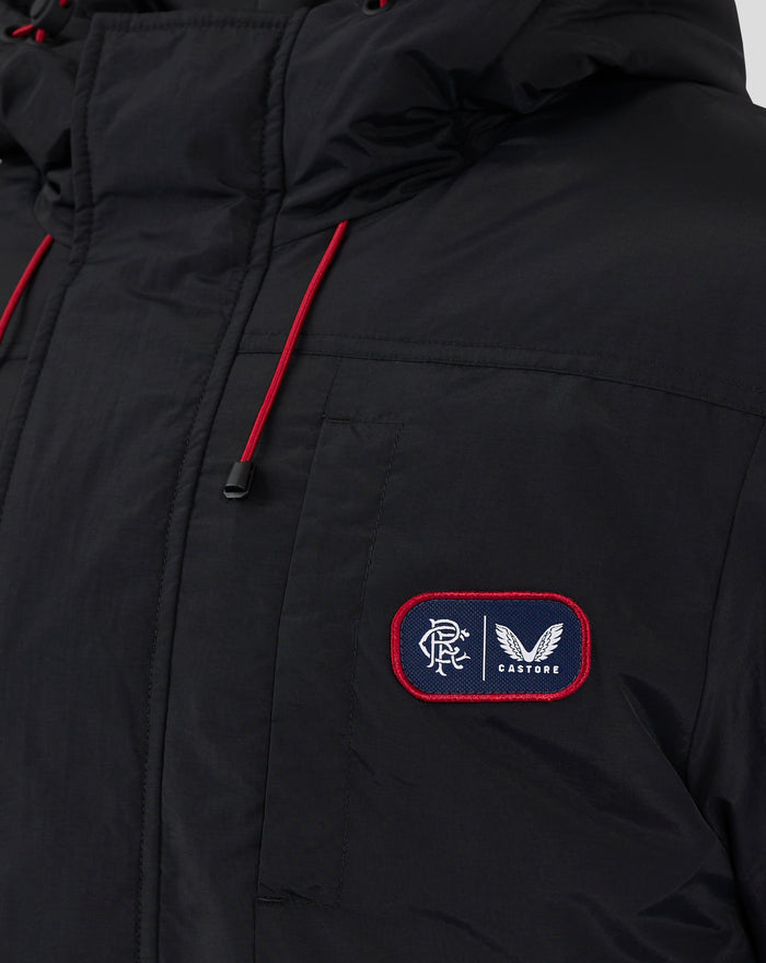 Close up of black winter jacket with hood and red drawstrings, featuring a blue crest patch on the chest.